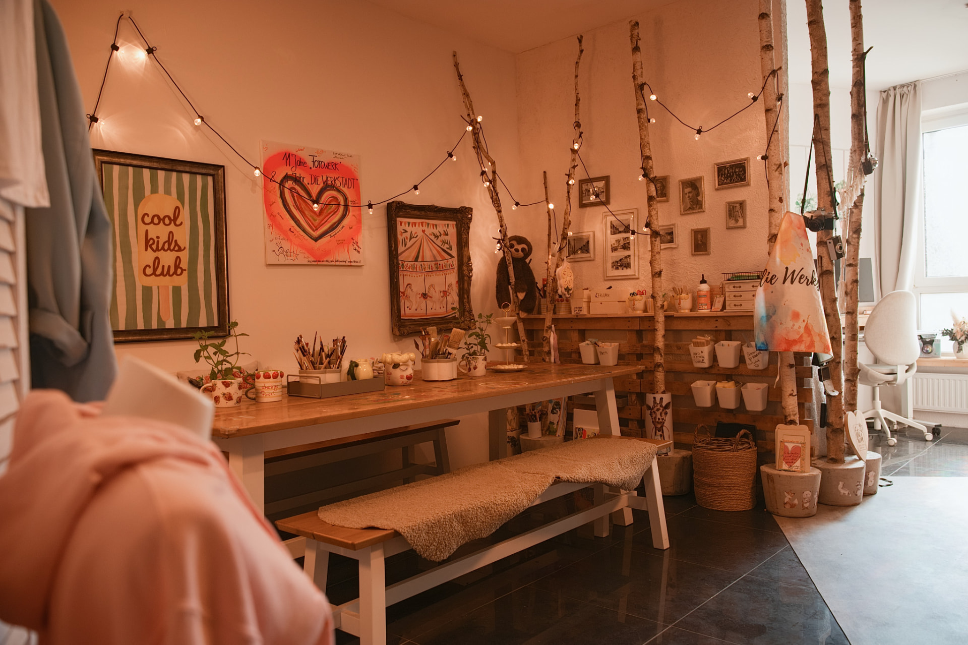 Das warme, einladende Interieur der Werkstadt mit Holztisch und gemütlicher Atmosphäre